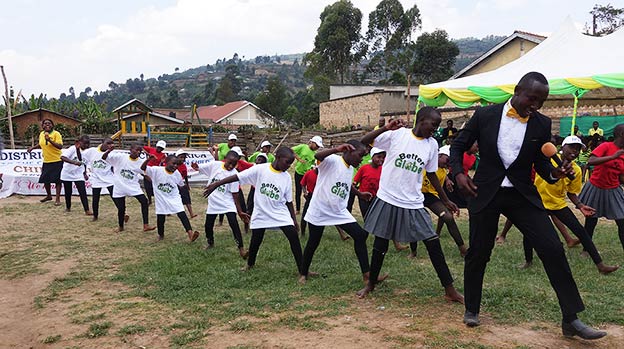 Isaac performing with happy children at Kabale School, Uganda